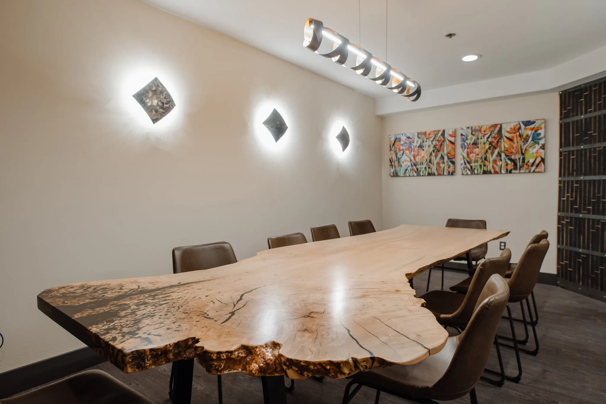 Dramatic live-edge maple slab dining table with natural bark inclusion and spalting, paired with modern leather chairs in a contemporary dining space.